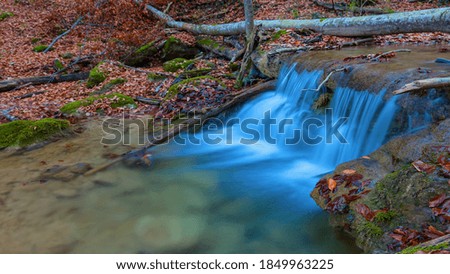 beautiful small waterfall on a mountain river, autumn mountain canyon natural landscape