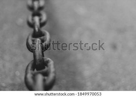 Black heavy metal chain on graphite asphalt background with copy space. Business strategy concept