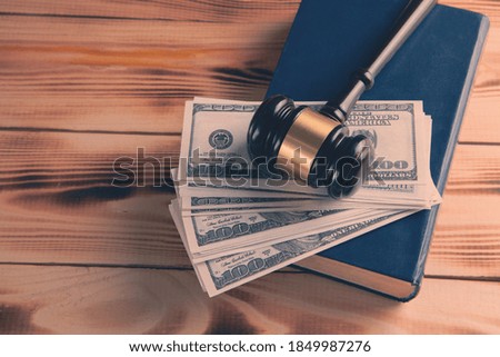 Judge gavel with dollars and law books
