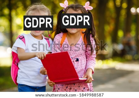 Portrait of the two cute little girls holding book. GDPR concept.