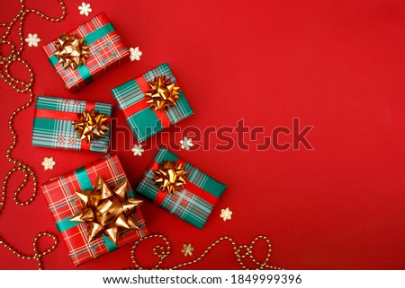 Christmas composition greeting card. Gifts on a red background. Top view, flat lay.