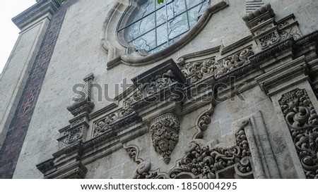 Low angle picture of a sculpted arch under a window from a building with byzantine architecture