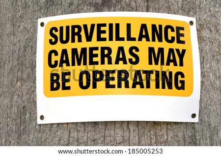 Surveillance cameras sign in the street reads: Surveillance cameras may be operating. concept photo of security, crime, criminality.