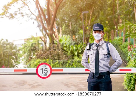 Asian security guard make saluting entry entrance the village. Security Guard with mask, protect covid-19 warning. Guard check entrance to the village. Speed 15 limit in area, copy space.