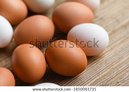 Fresh Chicken eggs and duck eggs on wooden background / white and brown egg