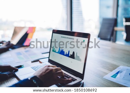 Cropped image of male analyst browsing business infographics during working process with statistics accounting on laptop computer, skilled trader checking web graphic charts via app on netbook