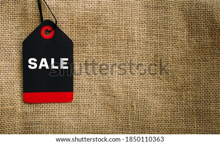 Stylish image of label on canvas bag with copy space. Tag with inscription on a string, close-up. Concept of November's total sales, Black Friday.