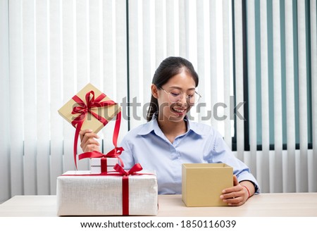 Asian women happy to open surprise box are stunned with excitement, joy and smile on holidays, Christmas, birthday or Valentine's Day concept.