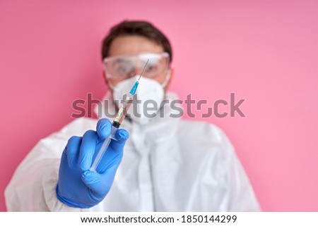 close-up of doctor or nurse hand with nitrile glove holding flu, measles vaccine shot for vaccination from covid-19, medicine and drug concept