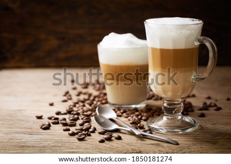glasses of latte macchiato coffee on a wooden background Royalty-Free Stock Photo #1850181274