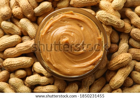 Jar with peanut butter on peanut background, close up Royalty-Free Stock Photo #1850231455