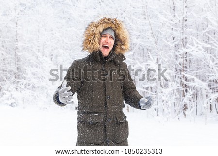 Happy funny male portrait looking snowflakes falling down