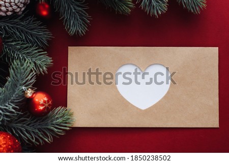 Fir tree branches, Xmas empty envelope on red background. Flat lay, top view, copy space. Concept of letter to Santa Claus