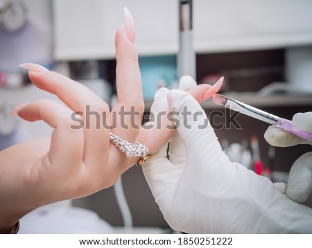 Professional manicure in salon. professional esthetician applies  acrylic gel on nails. Beautician women. Cosmetology