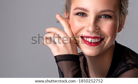 Happy girl with brown hair. Thin fashion model posing in the studio.  Attractive woman with bright makeup looking at  the camera. Beautiful caucasian girl smiling at camera.