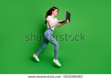 Full body profile side photo girl jump run search discount laptop wear t-shirt jeans isolated green bright color background