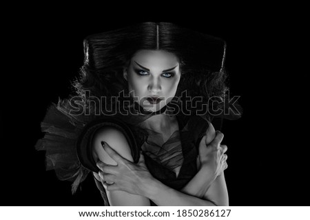 Portrait of beautiful glamour woman in costume and creative makeup, black and white image with local color in the iris and lips