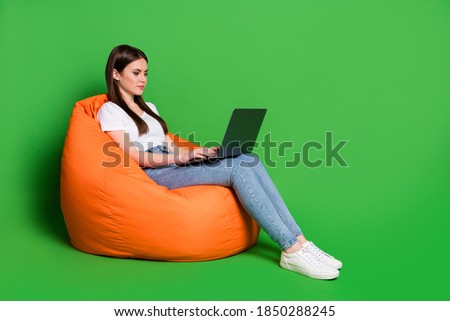 Profile photo of attractive lady hold computer texting reading email freelancer wear t-shirt jeans sneakers isolated green background