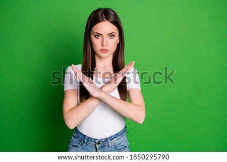 Photo portrait of woman making cross with hands isolated on vivid green colored background