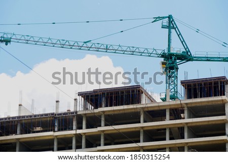 Construcrion site background. Concrete building under construction. Big tower crane. Industrial background.