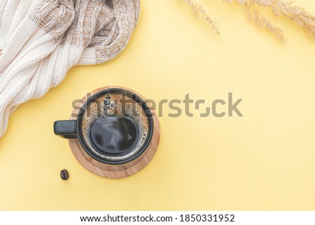 Morning composition: scarf on table with coffee mug, coffee beans. layout with space for text and ideas. Autumn season