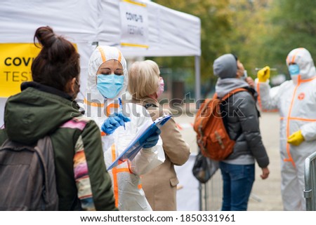People waiting in covid-19 testing center outdoors on street, coronavirus concept. Royalty-Free Stock Photo #1850331961
