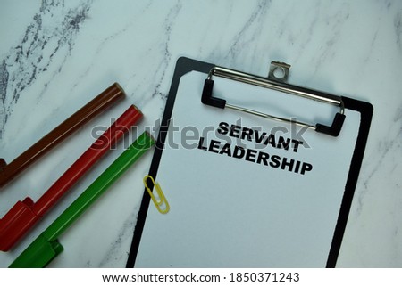 Servant Leadership write on paperwork isolated on Wooden Table. Royalty-Free Stock Photo #1850371243