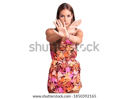 Young beautiful hispanic woman wearing casual clothes rejection expression crossing arms doing negative sign, angry face 