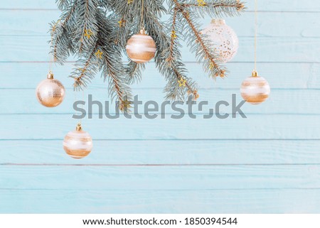 Christmas balls on fir branches on  blue wooden background