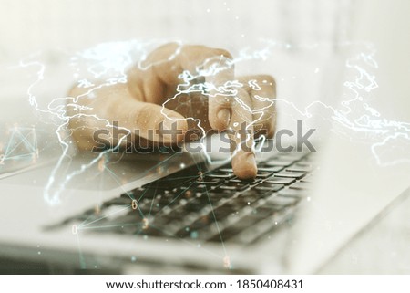 Abstract creative world map and hands typing on laptop on background, international trading concept. Multiexposure