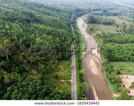 Aerial view of a asphalt road in the middle of the tropical green forest nature landscape