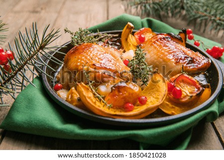 Roasted Christmas Chicken  thighs with pumpkin   for Christmas Dinner. Festive decorated wooden table