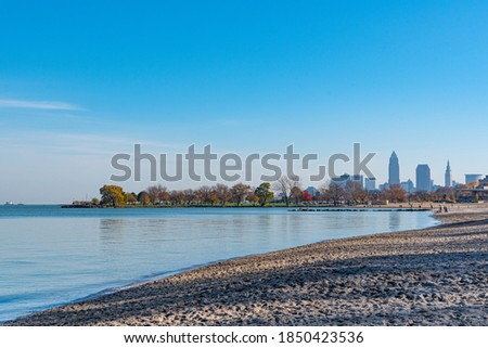 Downtown skyline next to lake with beach on sunny day