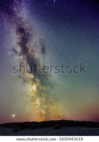 The milky way glowing on an dark summer sky over an stone wall, Sweden