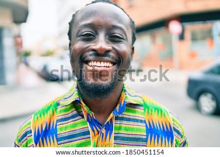 Young african american man smiling happy standing at street of city.