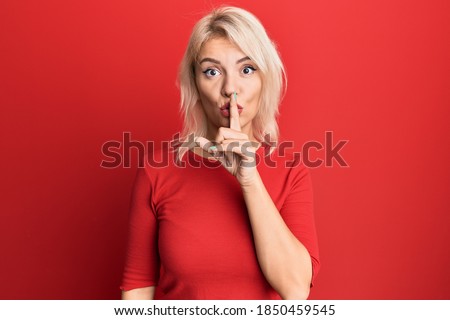 Young blonde girl wearing casual clothes asking to be quiet with finger on lips. silence and secret concept. 