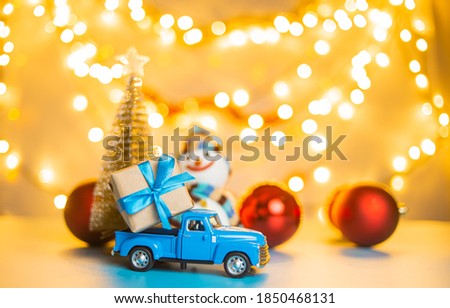 Blue retro toy car delivering gift box for christmas and new year