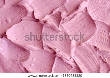 Pale pink cosmetic clay (alginate facial mask, face cream, body wrap) texture close up, selective focus. Abstract background with brush strokes. 