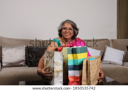 Beautiful Indian woman holding shopping bags and smiling.