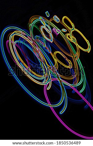 Light painting. Neon glow. Symmetry and reflection. Festive decoration. Abstract blurred background. Shining pattern.