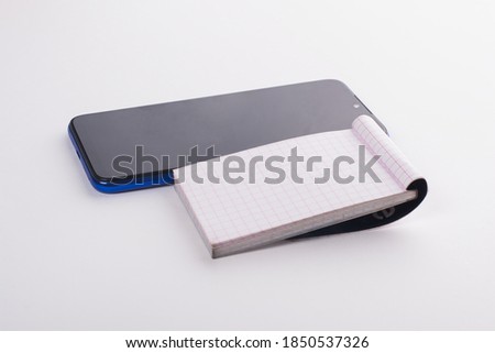 Modern smartphone and notebook with blank pages. Photo taken in studio on white isolated background