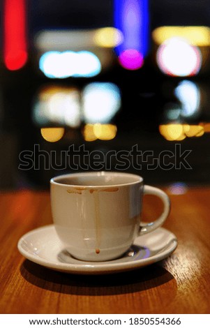 A cup of black coffee with a colorful light bokeh background