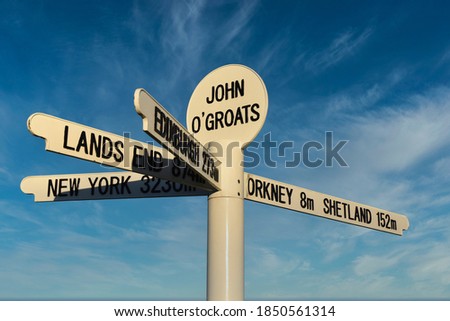 New John O'Groats signpost with blue sky and light cloud background. Caithness, Scotland, NC500 route. Royalty-Free Stock Photo #1850561314