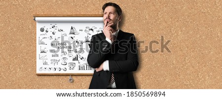 businessman thinking about a business plan on a whiteboard in front of cork background