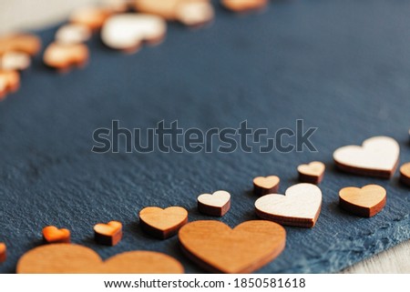 Valentines day background. Little wooden hearts on black board. Place for text