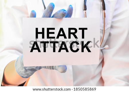The doctor's blue - gloved hands show the word HEART ATTACK- . a gloved hand on a white background. Medical concept. the medicine
