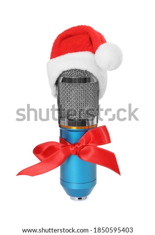 Microphone with Santa hat and red bow isolated on white. Christmas music
