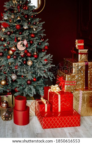 Gifts and gifts under the Christmas tree, winter holiday concept. Christmas gifts in a beautiful red package.