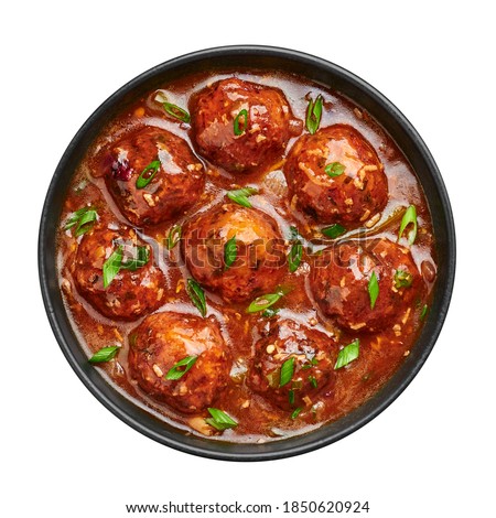 Veg Manchurian Gravy Balls in black bowl isolated on white. Vegetarian Manchurian is indian chinese cuisine dish. Asian food and meal. Top view Royalty-Free Stock Photo #1850620924