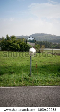 Two round mirrors in a rural road